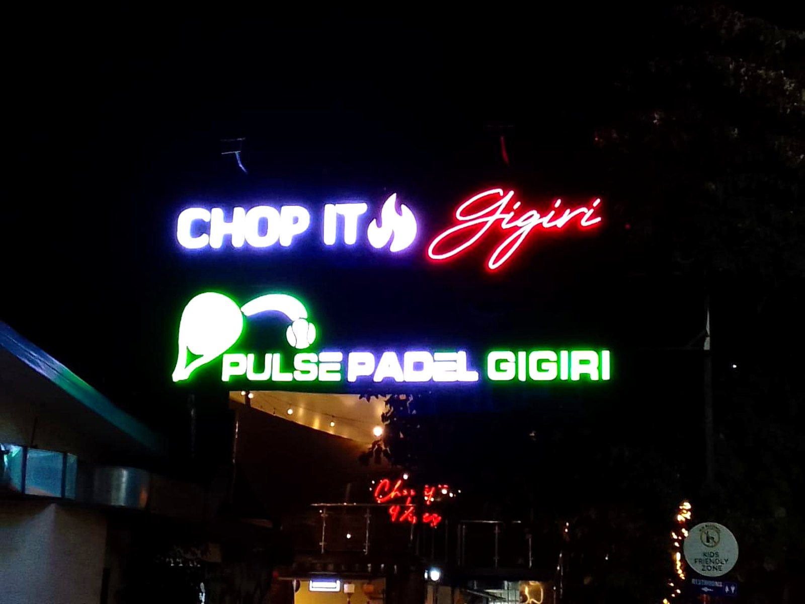 Neon-style Chop It Gigiri and Pulse Padel Gigiri signs lit up at night