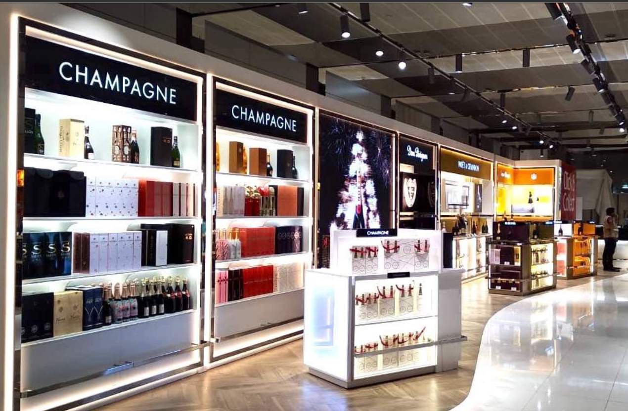 Champagne wall bays and illuminated displays in a duty free store, built by Display Dynamics